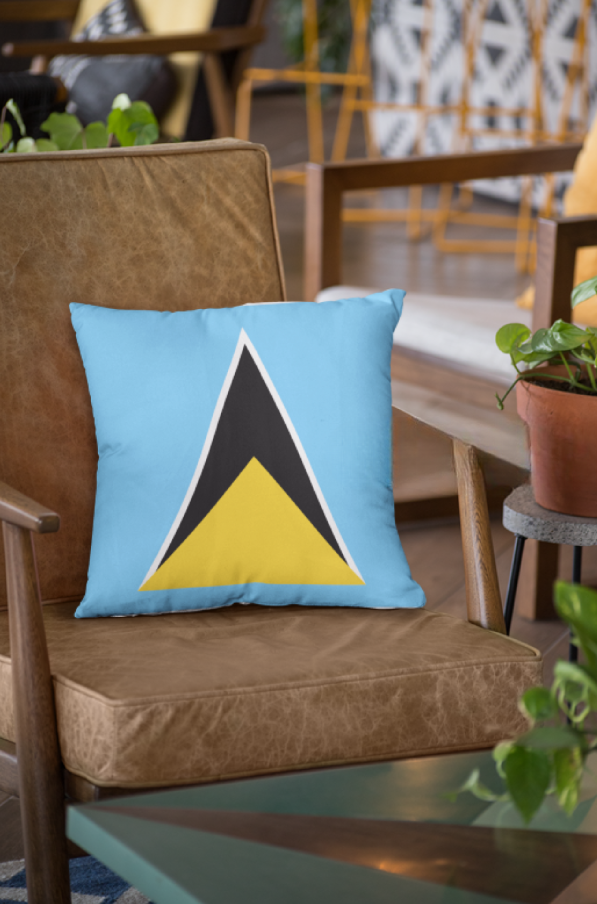 Woman holding a pillow with a geometric design, next to a pillow on a chair.