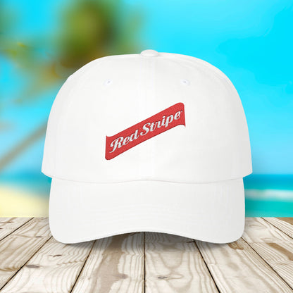 Jamaica Red Stripe Beer Logo Classic Dad Hat. The hat is a casual, curved-brim style with a structured front panel, featuring the Red Stripe Beer logo embroidered prominently in the center. The logo includes the signature red diagonal stripe and text, symbolizing the authentic Jamaican beer brand. The hat comes in a classic yet relaxed vibe, making it an ideal gift for beer enthusiasts, fathers, or anyone celebrating Jamaican heritage.