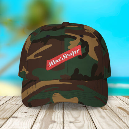 Jamaica Red Stripe Beer Logo Classic Dad Hat. The hat is a casual, curved-brim style with a structured front panel, featuring the Red Stripe Beer logo embroidered prominently in the center. The logo includes the signature red diagonal stripe and text, symbolizing the authentic Jamaican beer brand. The hat comes in a classic yet relaxed vibe, making it an ideal gift for beer enthusiasts, fathers, or anyone celebrating Jamaican heritage.