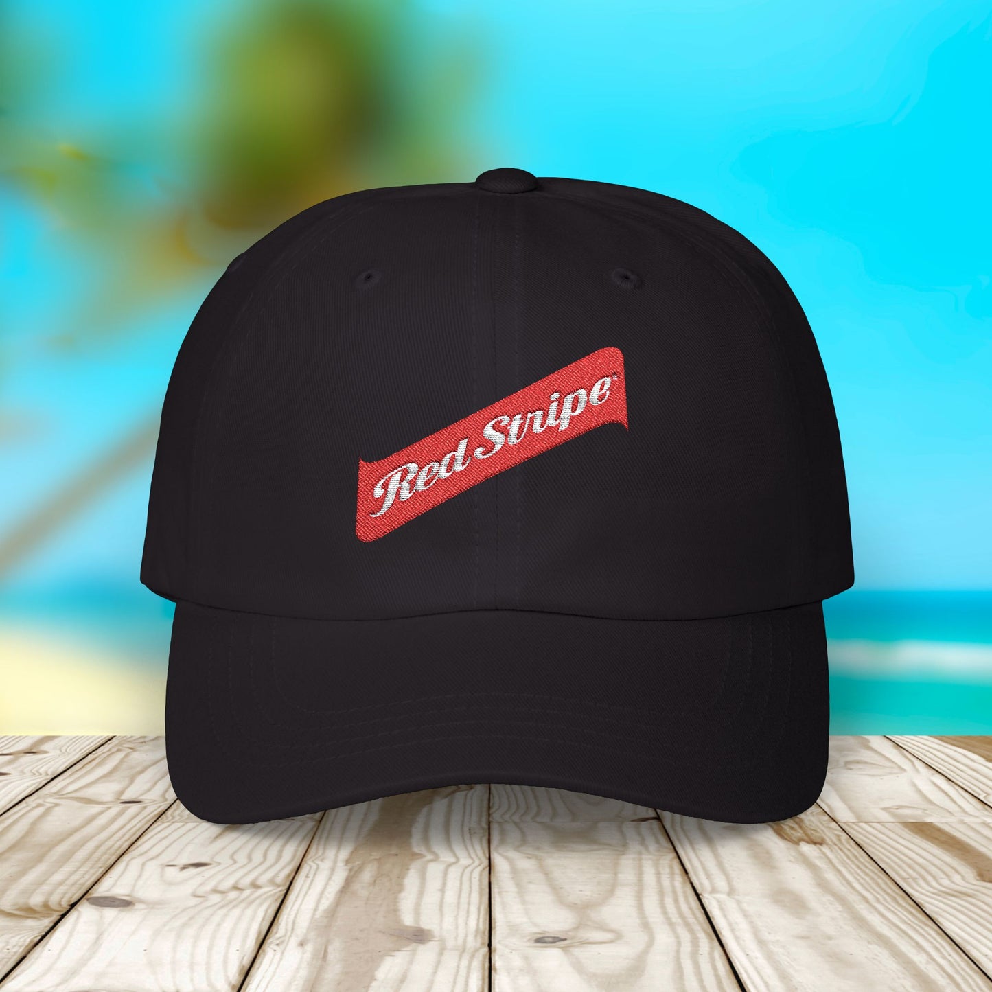 Jamaica Red Stripe Beer Logo Classic Dad Hat. The hat is a casual, curved-brim style with a structured front panel, featuring the Red Stripe Beer logo embroidered prominently in the center. The logo includes the signature red diagonal stripe and text, symbolizing the authentic Jamaican beer brand. The hat comes in a classic yet relaxed vibe, making it an ideal gift for beer enthusiasts, fathers, or anyone celebrating Jamaican heritage.