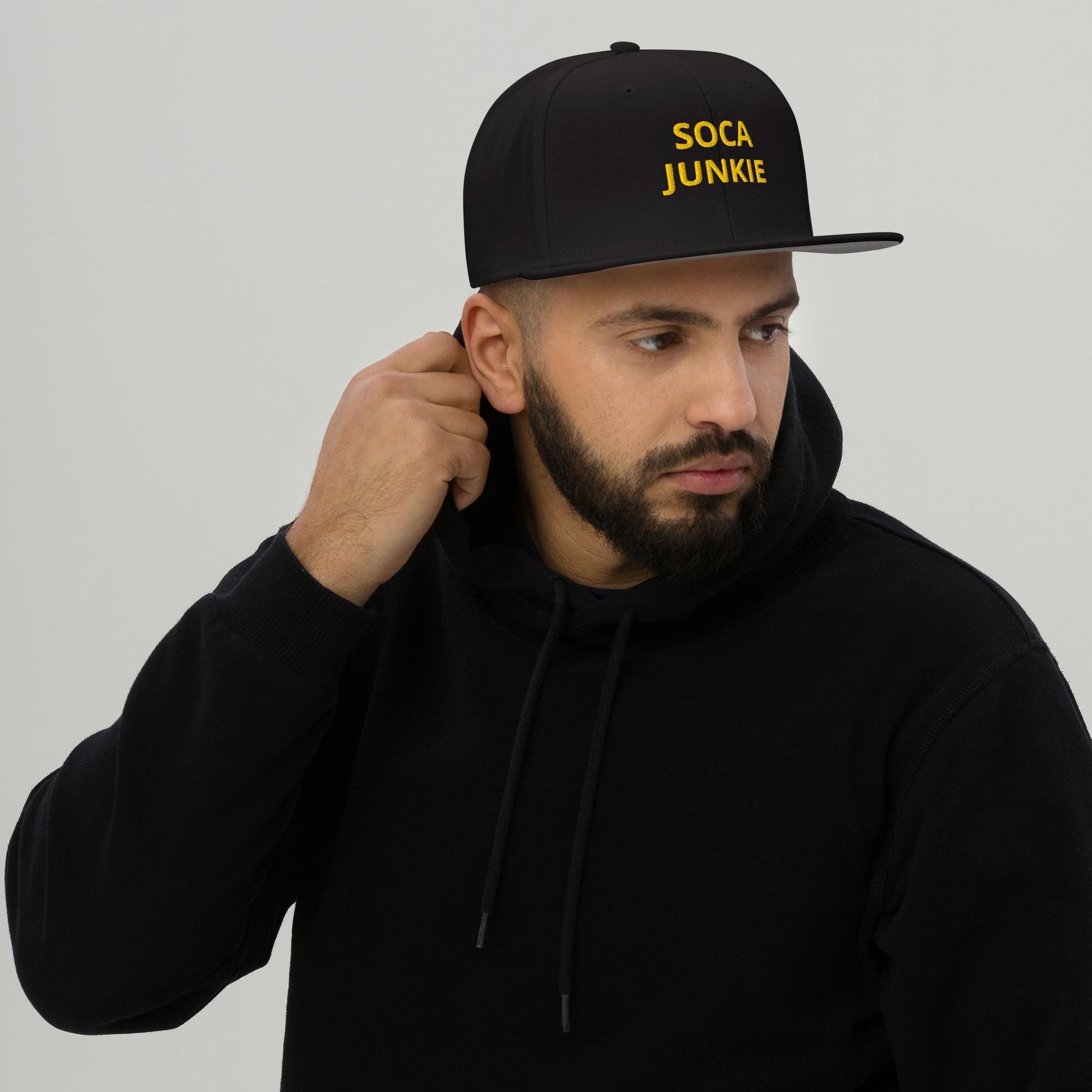 A sleek black snapback hat with &quot;Soca Junkie&quot; embroidered in bold, vibrant lettering on the front. This stylish cap is perfect for carnival fetes, music festivals, or everyday wear, celebrating Caribbean culture and Trinidad & Tobago vibes.