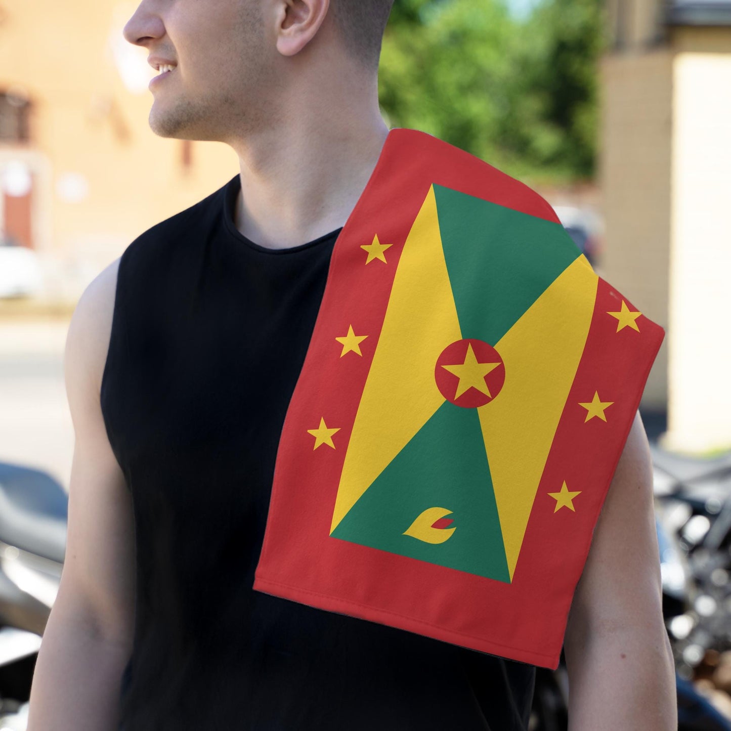 Grenada Flag Towel: Flag with a red background and a yellow, green pattern. A central red circle with a yellow star, surrounded by six yellow stars. Vibrant and bold Grenadian Rag for carnivals, fetes, and parties.